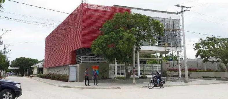 Fachada roja calada del centro comunitario CID de Santo Tomás.