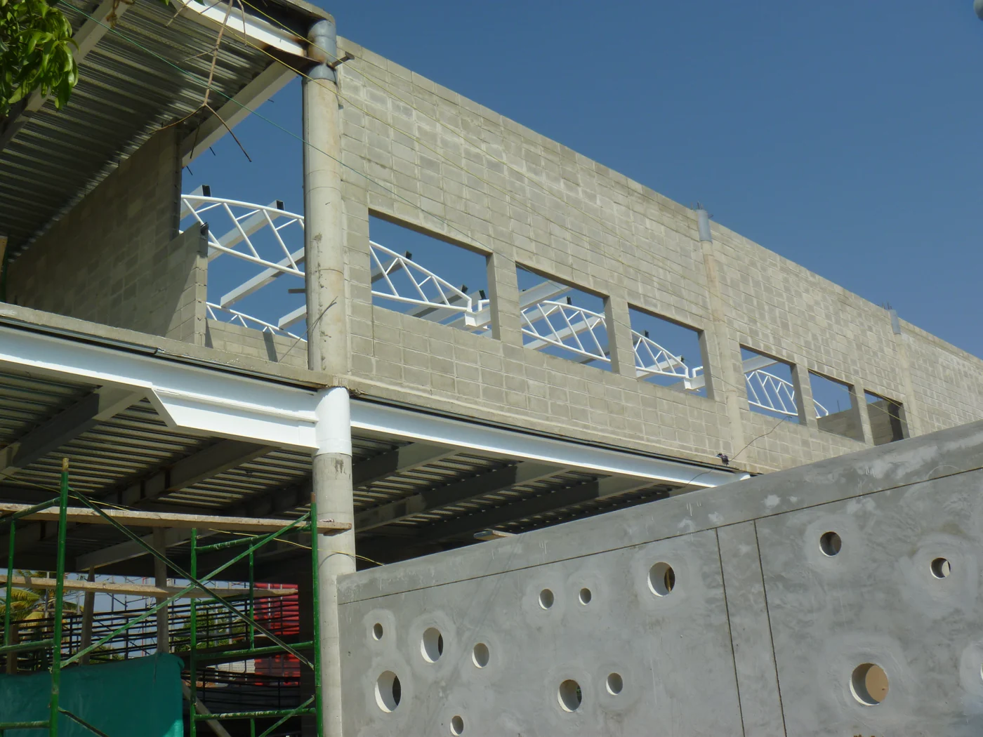 El muro de concreto perforado por óculos, ya levantado.