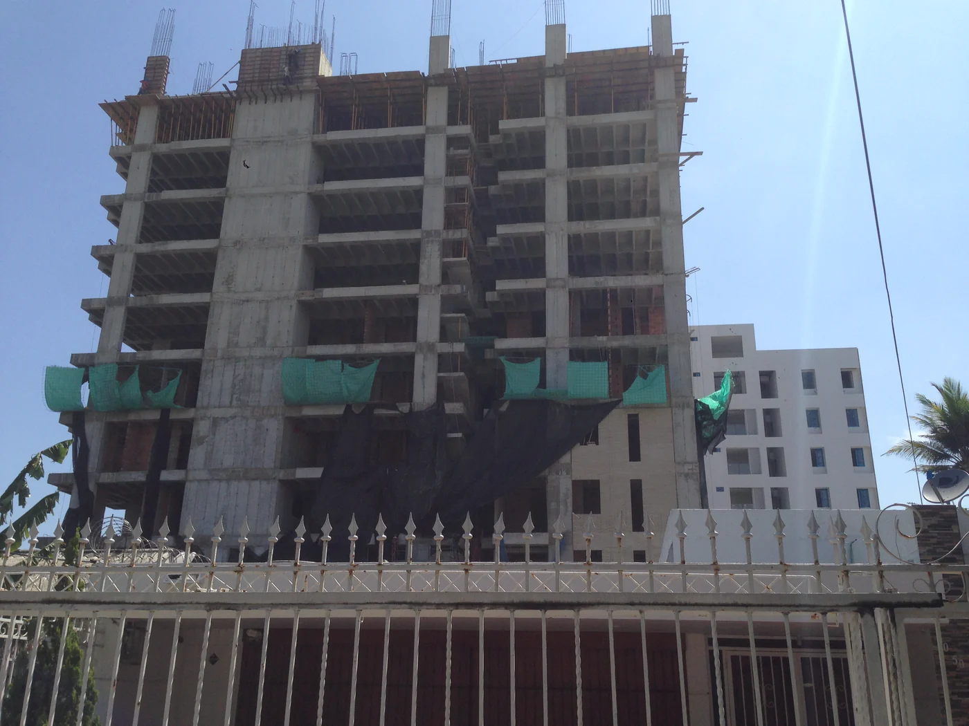 El esqueleto de concreto subiendo, con las mallas verdes en cada piso.